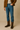 "Men’s dark brown Western cowboy boots styled with blue jeans, tan suede jacket, and cream sweater, name-brand and designer men’s boots modeled for casual fall fashion against neutral background."