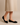 "Woman wearing black suede ballet flats paired with a beige midi skirt, name-brand women’s flats modeled for casual and office wear against neutral background."