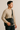 "Men’s black leather crossbody messenger bag styled with beige sweater and dark pants, name-brand men’s bag modeled for work and everyday use against neutral background."
